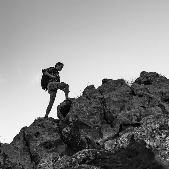 Mann, der einen Feldpass hinaufsteigt um sein Ziel zu erreichen